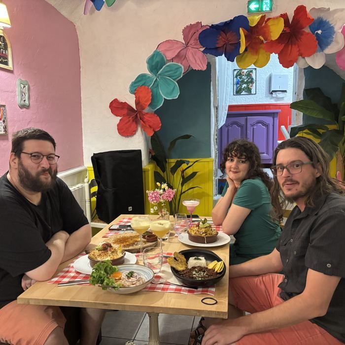 Des clients attablés au Barrio Latino, plats et cocktails partagés au centre de la table.