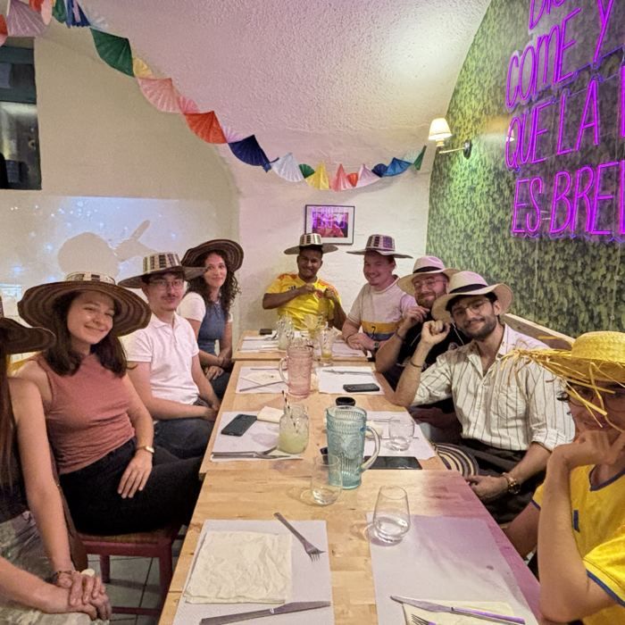 Groupe de clients coiffés de sombreros, tout sourire dans la salle du Barrio Latino.