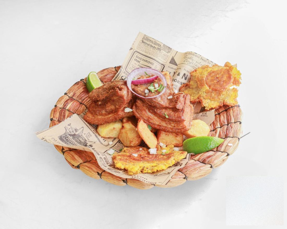 Le chicharrón : morceaux de poitrine de porc croustillante, pommes de terre sautées, bananes plantains écrasées et quartiers de citron vert.